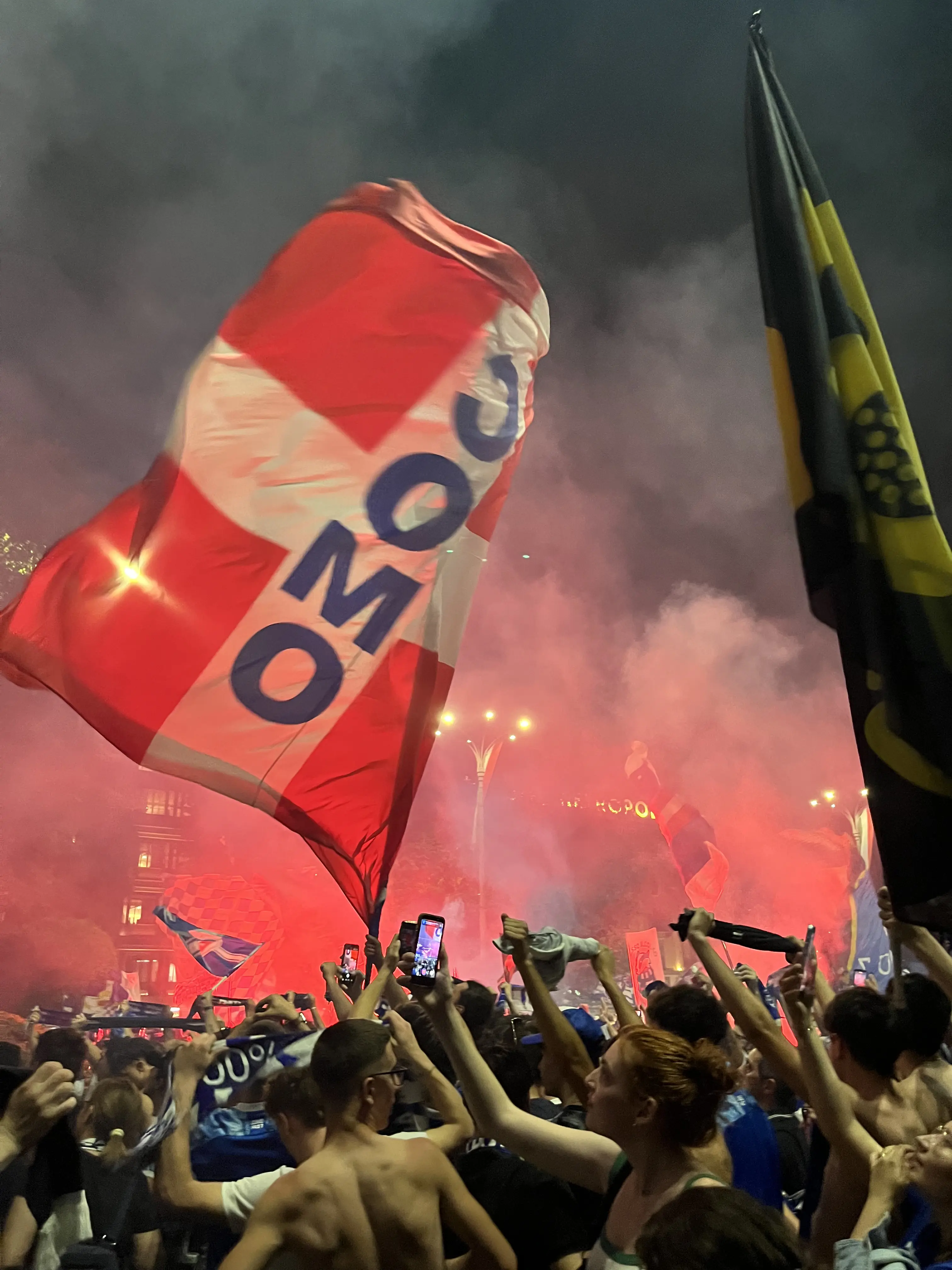 Grande bandiera del Como tra fumogeni e tifosi